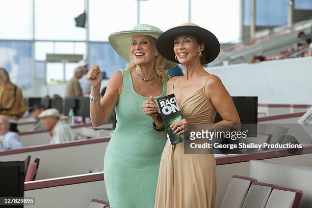 upscale senior women enjoying a horse race - race spectator stock pictures, royalty-free photos & images