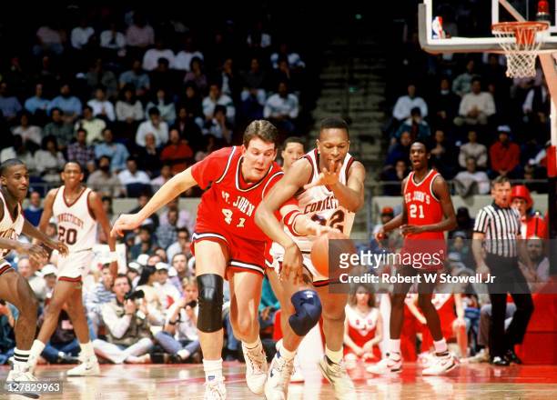 American basketball player Robert Werdann of St. John's University tries to steal the ball from Rod Sellers of the University of Connecticut during a...