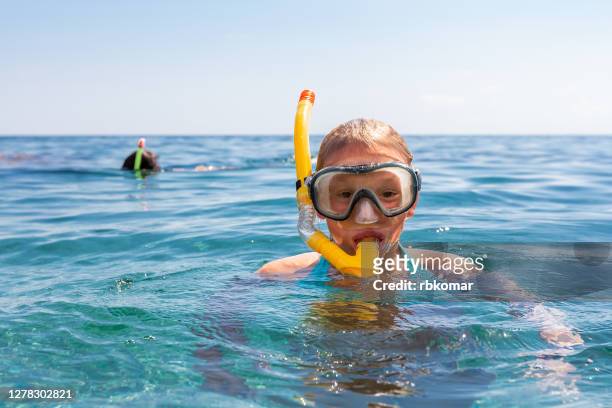 snorkeling equipment. snorkel and mask for diving under water. people in goggles swim in the blue sea - scuba diving girl stockfoto's en -beelden