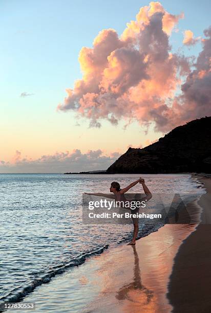 a woman doing yoga on a beach - san cristobal fotografías e imágenes de stock