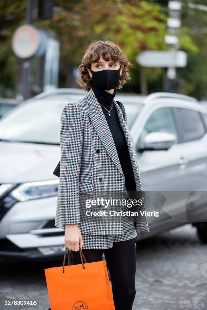 Model is seen wearing grey checked blazer and shorts, black turtleneck outside Hermes during Paris Fashion Week - Womenswear Spring Summer 2021 : Day...