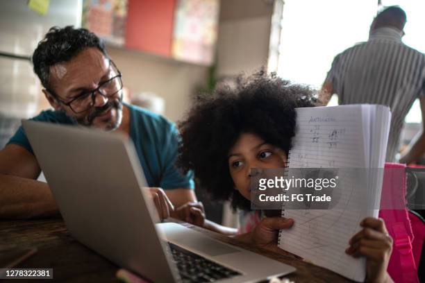 father helping daughter during videochat/homeschooling at home - remote location stock pictures, royalty-free photos & images