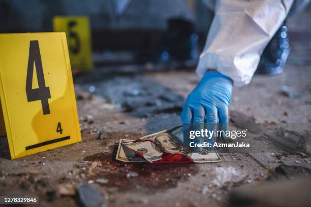 gloved hand pick up bloody us currency op crime scene - agent cash stockfoto's en -beelden