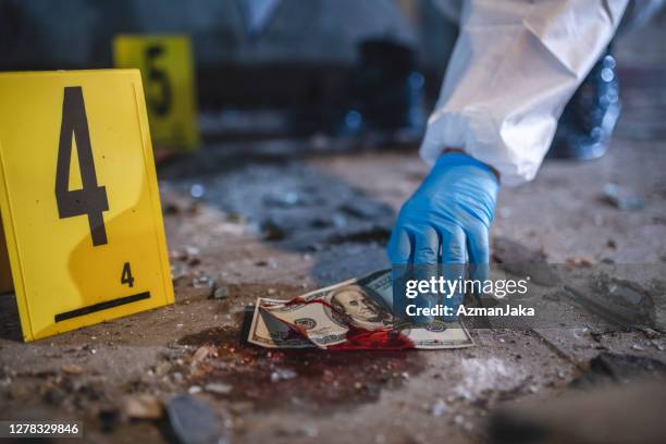 gloved hand picking up bloody us currency at crime scene - slovenia police stock pictures, royalty-free photos & images