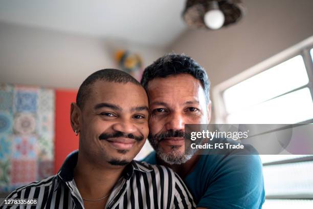 portrait of a homosexual couple at home - gay man stock pictures, royalty-free photos & images