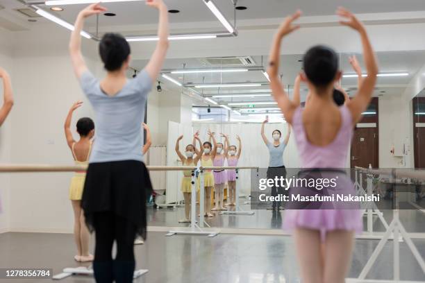 asian children ballet students and asian instructor in the mirror are taking lesson in studio with ballet lesson bar. - atelier food stock-fotos und bilder