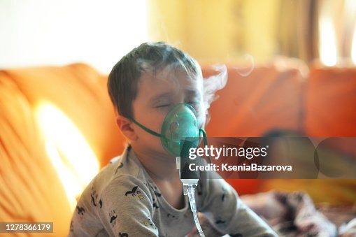 The boy breathes through the inhaler. The boy is being treated The boy breathes through the inhaler. The boy is being treated