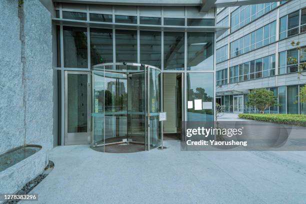 modern entrance with revolving door, - apartment exterior ストックフォトと画像