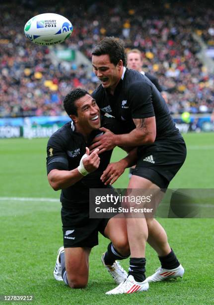 Fullback Mils Muliaina of the All Blacks is congratulated by teammate Zac Guildford after scoring his team's fifth try during the IRB Rugby World Cup...