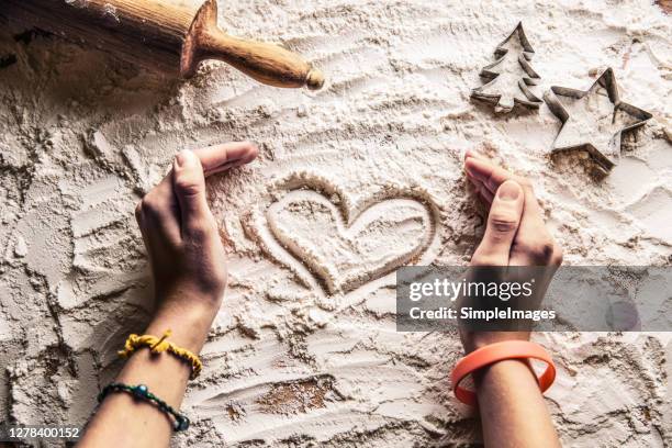 heart of flour womans hands rolling pin on bakery table, top view. chrisrmas day. - rolling pin photos et images de collection