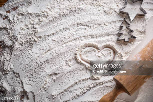 heart of flour and rolling pin on a bakery table. christmas day. - chopping block flour stock pictures, royalty-free photos & images