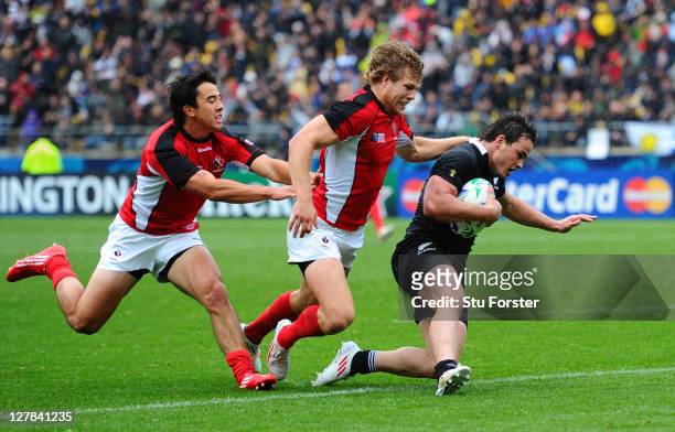 Wing Zac Guildford of the All Blacks evades Ryan Smith and Conor Trainor of Canada to score his fourth try and his team's eleventh try during the IRB...