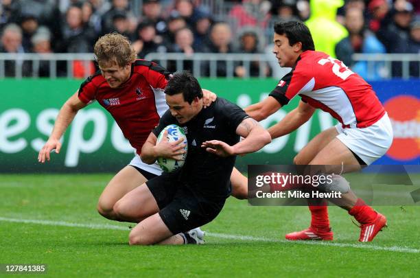 Wing Zac Guildford of the All Blacks evades Conor Trainor and Ryan Smith of Canada to score his fourth try and his team's eleventh try during the IRB...