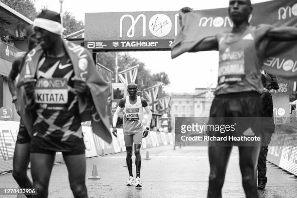 Eliud Kipchoge of Kenya reacts as he crosses the line as first place Shura Kitata of Ethiopia and second place Vincent Kipchumba of Kenya celebrate...
