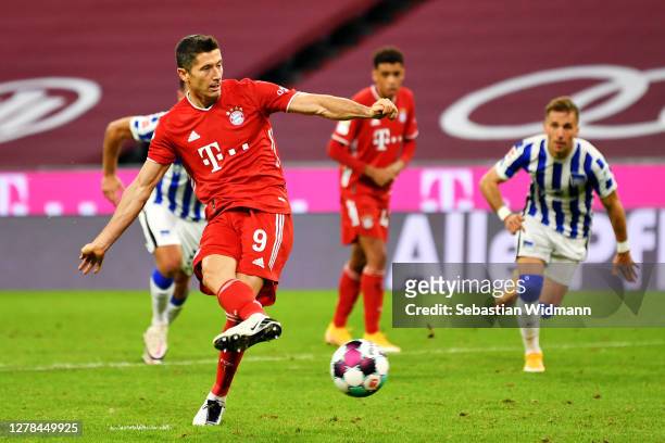 Robert Lewandowski of Bayern Munich scores his team's fourth goal from the penalty spot to complete his hat-trick during the Bundesliga match between...