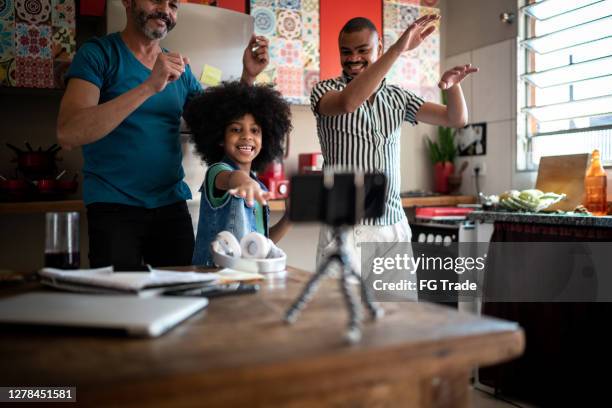 familia bailando en casa, usando un teléfono inteligente en un trípode para filmar - papa niña baile fotografías e imágenes de stock