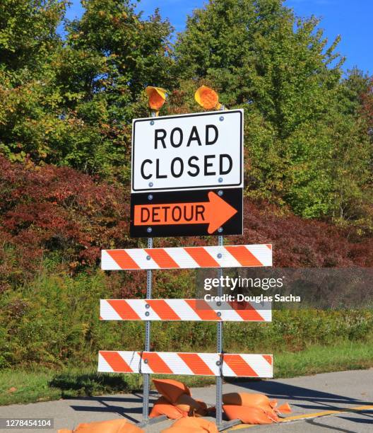 closed road sign and barricade on the highway - straßensperre stock-fotos und bilder