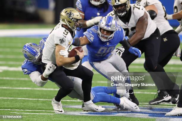 Drew Brees of the New Orleans Saints is sacked by Trey Flowers and Romeo Okwara of the Detroit LIons during the second quarter at Ford Field on...