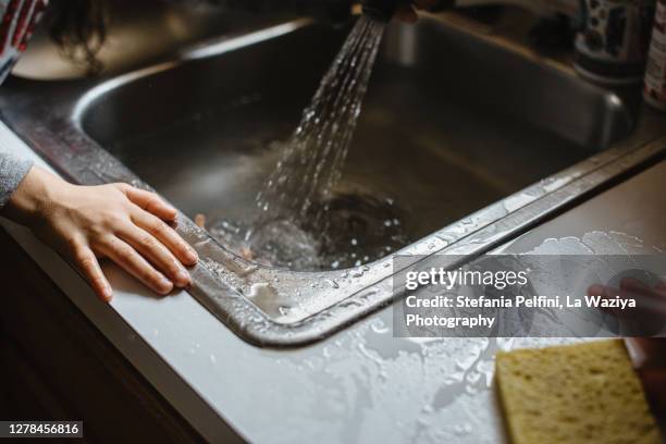 wet and messy kitchen sink as a result of a child play - desperdício de água imagens e fotografias de stock
