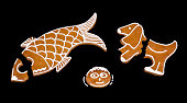 Broken gingerbreads cookies in fish, dog or face shape isolated on a black background