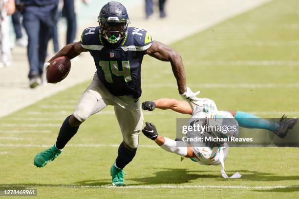 Metcalf of the Seattle Seahawks breaks a tackle from Nik Needham of the Miami Dolphins during the fourth quarter at Hard Rock Stadium on October 04,...