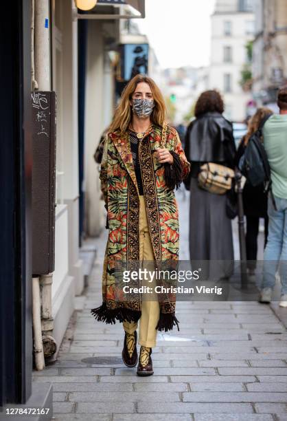 Guest is seen wearing coat with print, beige pants outside Paco Rabanne during Paris Fashion Week - Womenswear Spring Summer 2021 : Day Seven on...