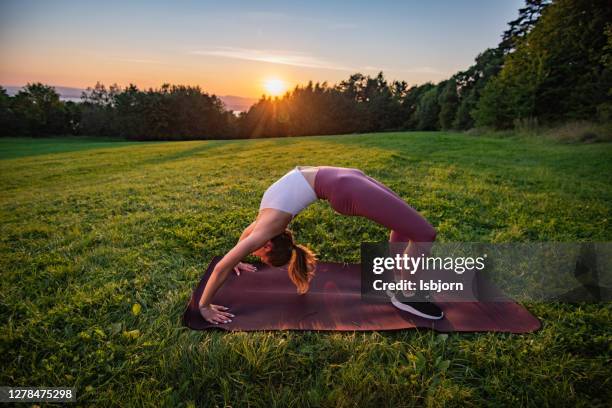 fitness-frau tun brücke pose im freien. - acrobatic yoga stock-fotos und bilder