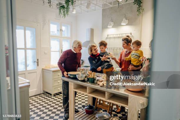 familie bereitet thanksgiving-dinner in der küche - festliches abendessen stock-fotos und bilder