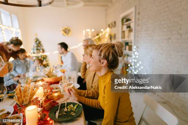 multigenerational family celebrating december holidays - christmas meal stock pictures, royalty-free photos & images