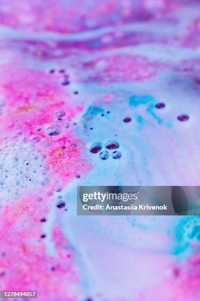 pink and blue bath bomb dissolving in the water. - bath bomb stock pictures, royalty-free photos & images