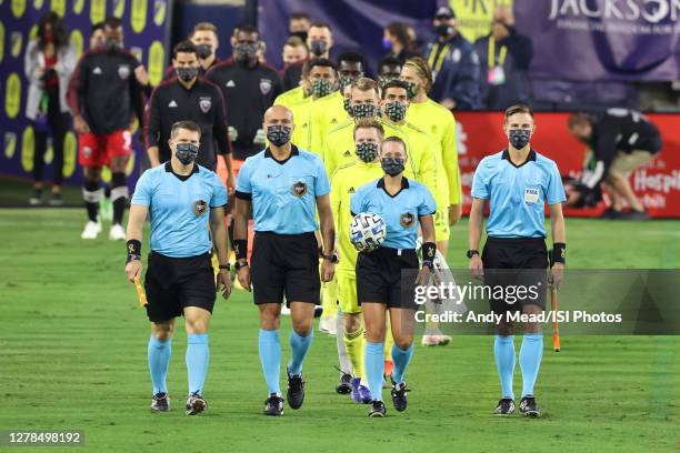 Referee Tori Penso carries the match ball while she and assistant referees Logan Brown and Jeremy Hanson and fourth official Robert Sibiga lead the...