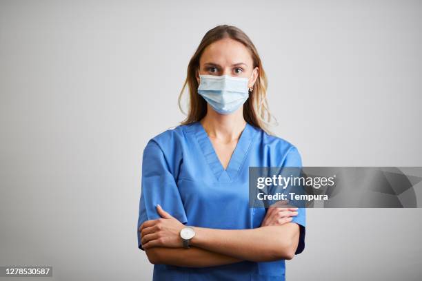 portrait of a smiling female doctor in medical scrubs. - corona virus white background stock pictures, royalty-free photos & images