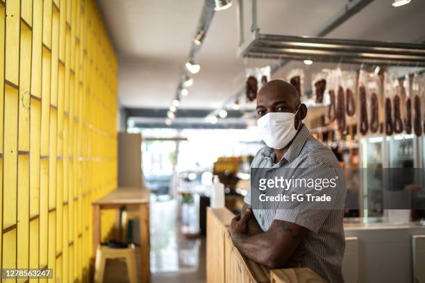 portrait of a small business owner using face mask - small business mask stock pictures, royalty-free photos & images