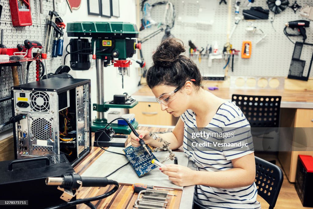 Young woman repairing and assembling pc computer