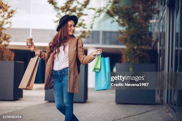 glückliche frau mit spaß beim einkaufen - shopping spree stock-fotos und bilder