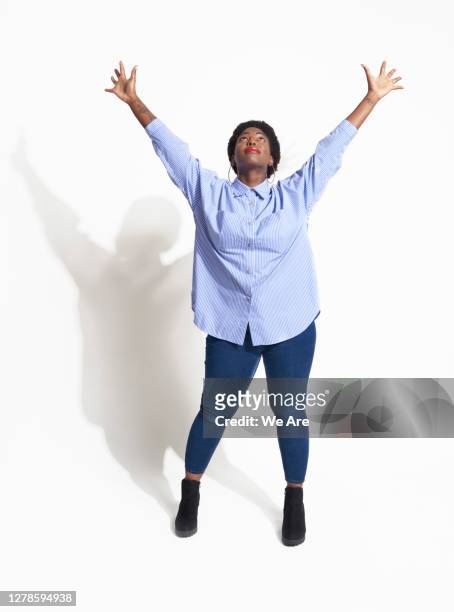 woman standing with arms in the air - braccia alzate foto e immagini stock