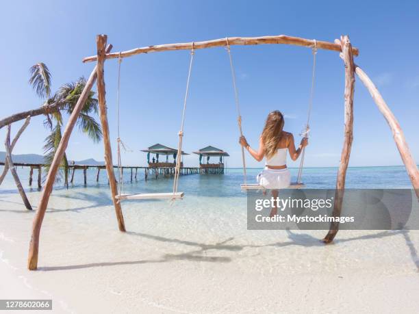 young woman on swing on tropical beach - vietnam beach stock pictures, royalty-free photos & images