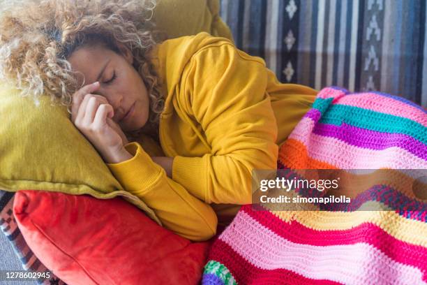 Lonely adult beautiful woman sleep at home in day light time - tired and stressed out people concept sleeping on the couch  - colors lifestyle people relaxing concept