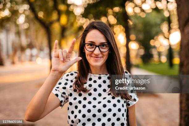 frau zeigt "liebe" auf gebärdensprache - american sign language stock-fotos und bilder