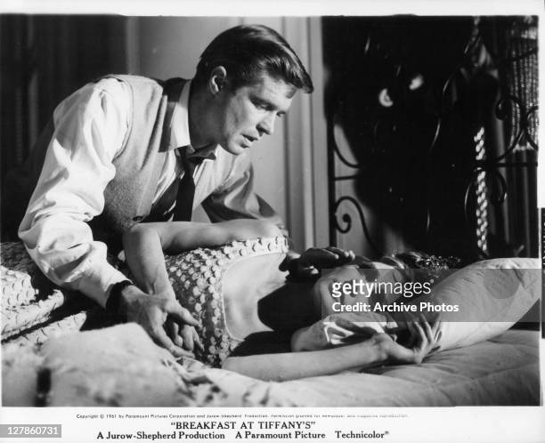 George Peppard leaning over Audrey Hepburn in bed in a scene from the film 'Breakfast At Tiffany's', 1961.
