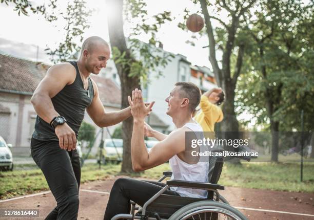 gehandicapte mensen die basketbal met vrienden spelen - gehandicapte atleet stockfoto's en -beelden