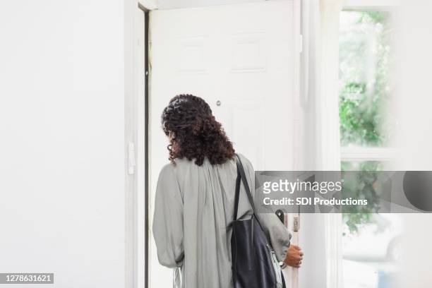 incognizable joven adulta mujer deja casa llevando bolso - leave fotografías e imágenes de stock