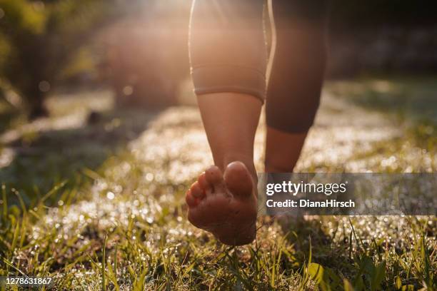 junge frau bei walk-meditation in ihrem garten - man barefoot stock-fotos und bilder