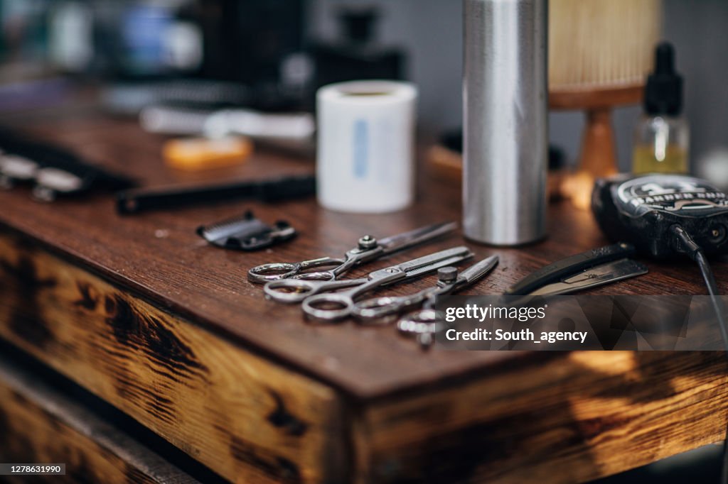 De hulpmiddelen van de kapper op houten plank bij de kapperswinkel