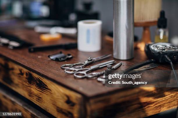 de hulpmiddelen van de kapper op houten plank bij de kapperswinkel - barbier stockfoto's en -beelden