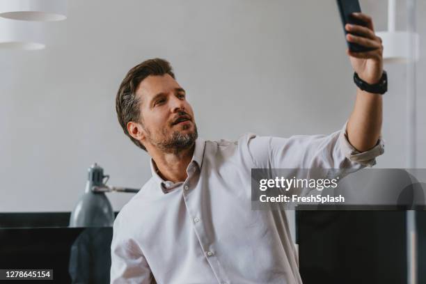 handsome businessman macht ein selfie bei der arbeit - eitelkeit stock-fotos und bilder