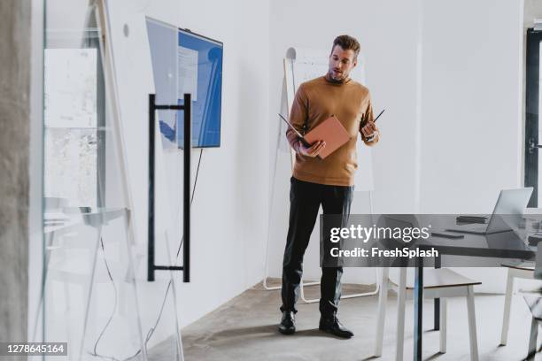 junger geschäftsmann präsentiert seine ideen in einem meeting - turtleneck stock-fotos und bilder