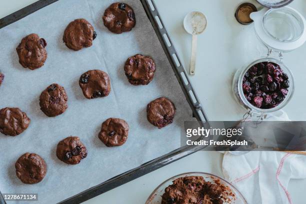 chocolate chip cookies on a baking tray, an overhead view - baking tray stock pictures, royalty-free photos & images