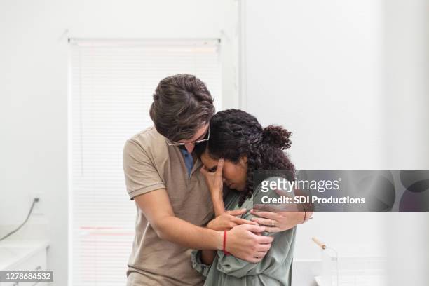 young husband comforts  wife - man cry touching stock pictures, royalty-free photos & images