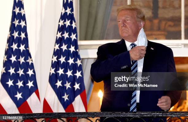 President Donald Trump removes his mask upon return to the White House from Walter Reed National Military Medical Center on October 05, 2020 in...